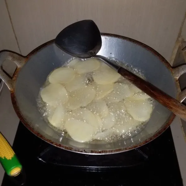 Panaskan minyak goreng. Ambil irisan kentang secukupnya. Masukan ke dalam minyak panas, sambil di aduk agar tidak menempel. Goreng dengan minyak penuh.