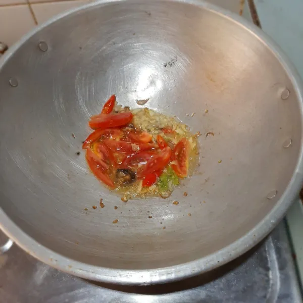 Tumis duo bawang dan cabai rawit hingga harum, lalu masukkan tomat dan lengkuas.