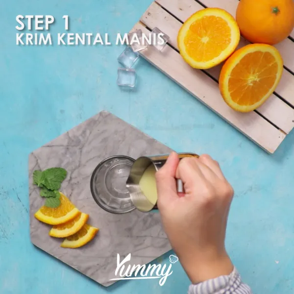 Siapkan gelas saji, masukkan krim kental manis dan jeruk kaleng.