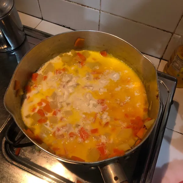 Masukkan kentang dan wortel dan juga susu, masak hingga mengental.