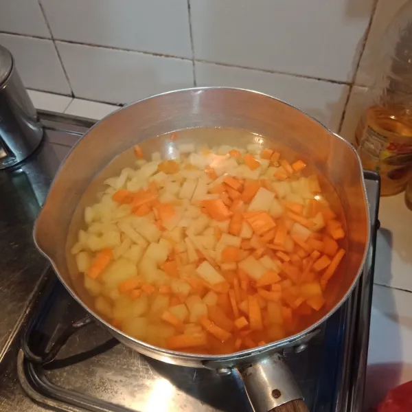 Potong wortel dan kentang kecil-kecil dan rebus hingga setengah matang.