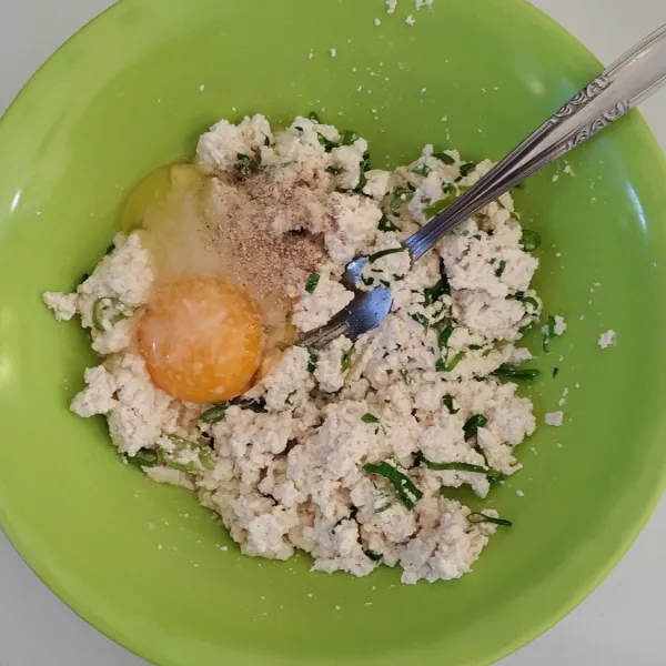 Tambahkan telur, garam, merica, kaldu bubuk, dan juga bawang putih bubuk. Aduk sampai tercampur rata.