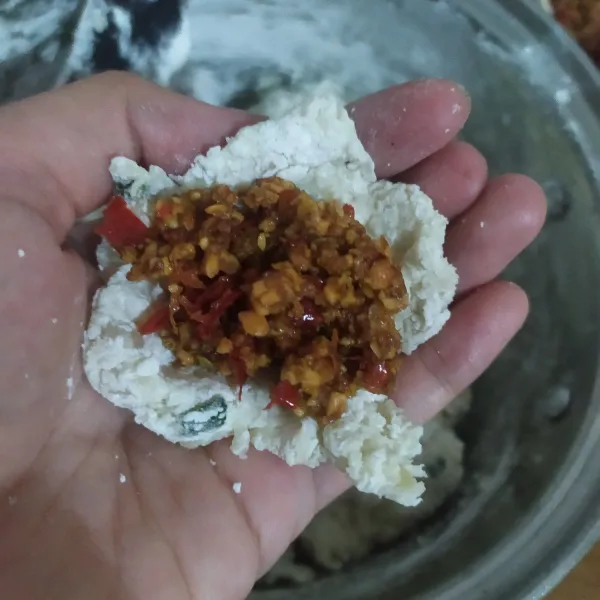 Ambil secukupnya adonan, pipihkan beri sambal kacang, tutup rapat dengan cara dicubit-cubit, dan bentuk adonan menjadi bulat pipih, lakukan sampai habis.