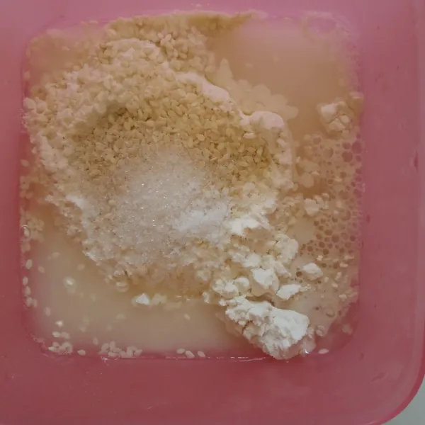 Campur tepung terigu, maizena, wijen, gula, dan garam. Tambahkan air sedikit demi sedikit campur rata sampai menjadi adonan yang tidak terlalu kental tapi juga tidak encer