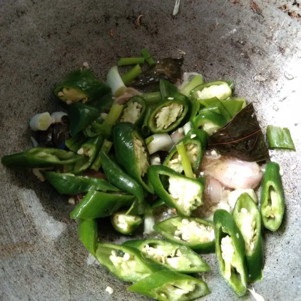 Masukkan irisan cabai hijau dan daun bawang, aduk rata