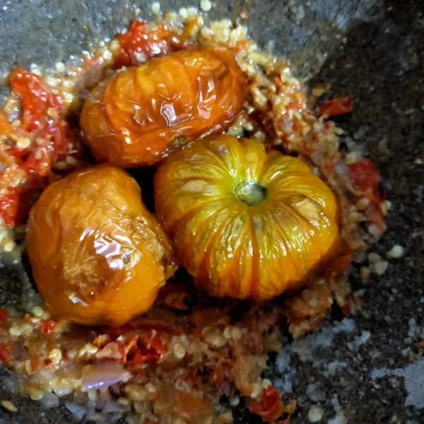 Masukkan tomat lalu ulek lagi. Setelah itu tambahkan jeruk purut.