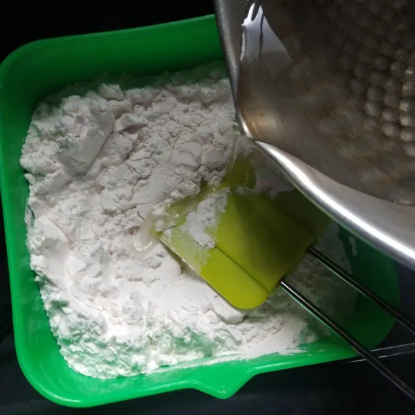 Campur tepung dan garam, aduk rata kemudian tuang air panas