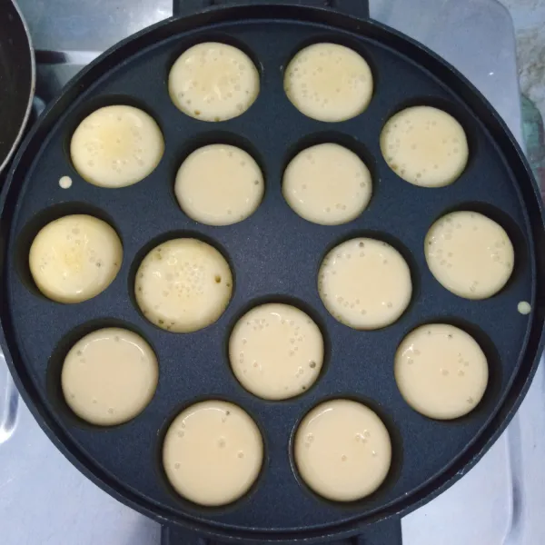 Panaskan cetakan. Kemudian tuang adonan secukupnya. Panggang sampai setengah matang.