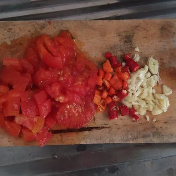 Cincang halus bawang putih, iris cabe, dan cincang halus tomat yang sudah direbus.