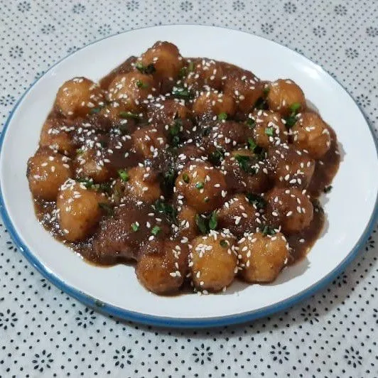 Tuang tahu bakso bumbu kecap ke piring saji, taburi dengan wijen, dan irisan seledri. Tahu bakso kecap tabur wijen siap dihidangkan.