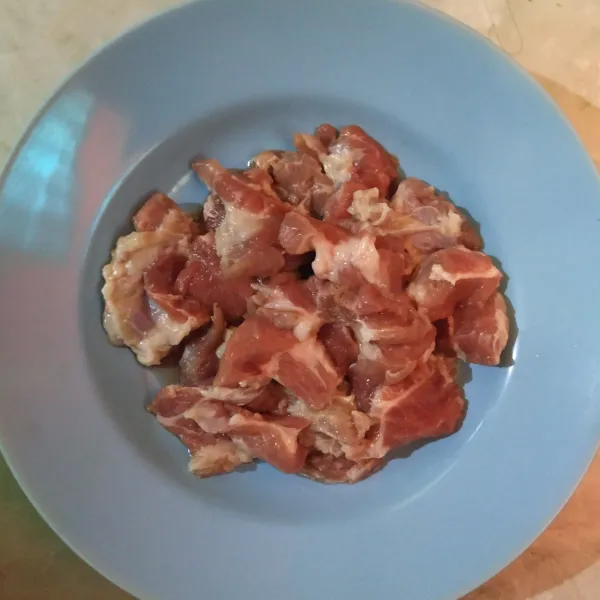 Potong-potong daging babi sesuai selera.