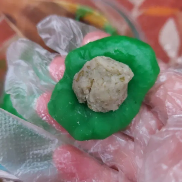 Ambil adonan kue mochi yang sudah hangat secukupnya lalu isi dengan kacang hijau. Bentuk bulat kemudian gulingkan ke dalam tepung meizena, aduk hingga tertutup rapat.