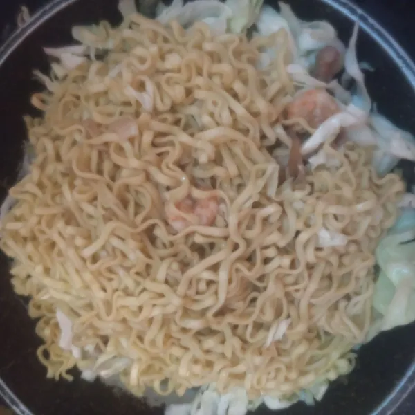 Masukkan mie dan bumbunya. Aduk dengan rata. Terakhir masukkan kubis. Sajikan.