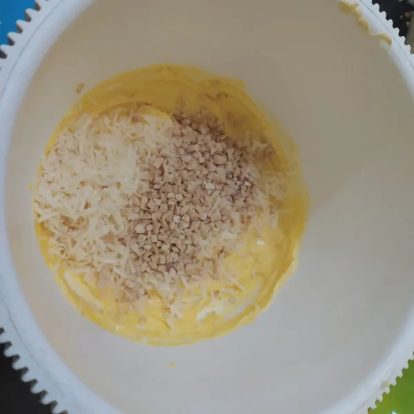Masukan keju parut dan kacang, aduk rata.
