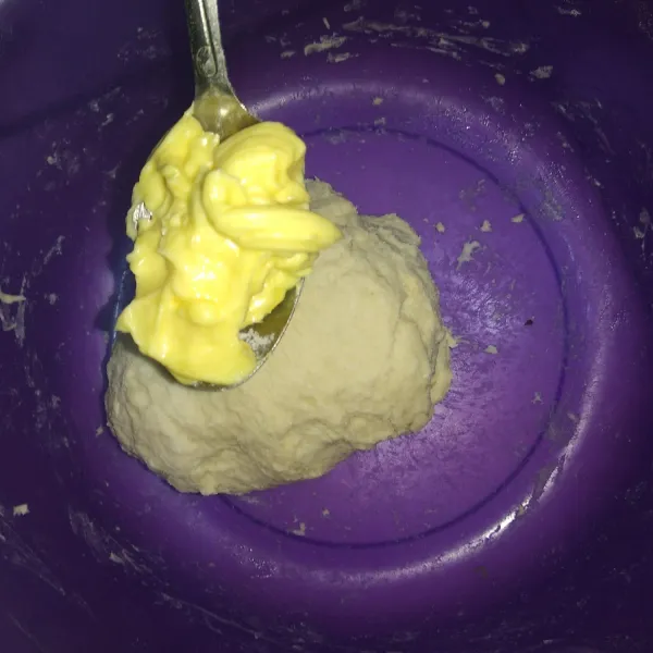 Setelah tercampur masukkan mentega, uleni kembali sampai adonan kalis.