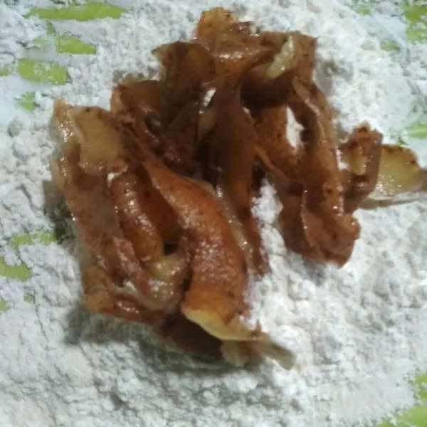 Gulingkan kulit kentang dicampuran tepung sambil ditekan-tekan agar tepung menempel sempurna.