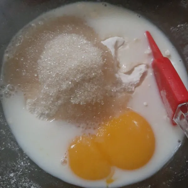Campurkan kuning telur, tepung terigu, gula, susu, baking powder, dan vanilla bubuk. Aduk rata.