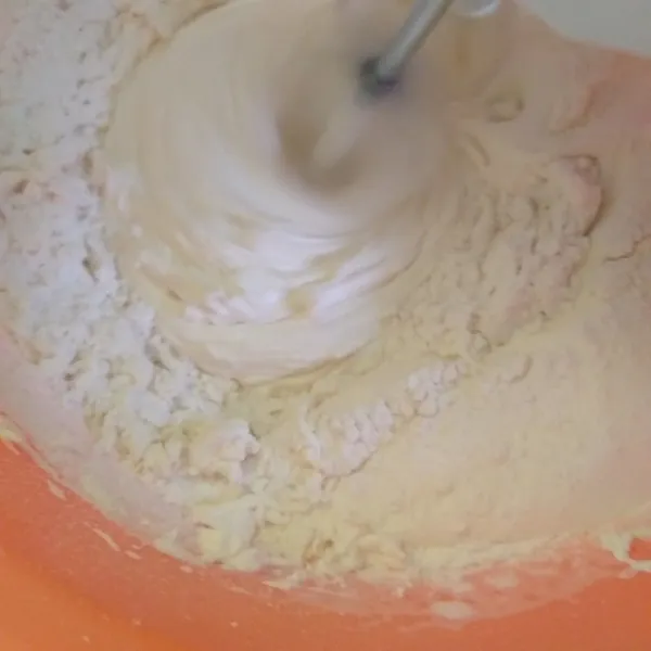 Turunkan speed mixer, tuang terigu perlaha, dan aduk rata. Matikan mixer.
