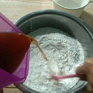 Masukkan larutan gula merah kedalam tepung, aduk-aduk hingga tercampur rata.