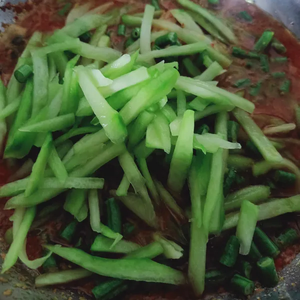 Tuang labu siam dan kacang panjang. Aduk rata lalu masukkan air