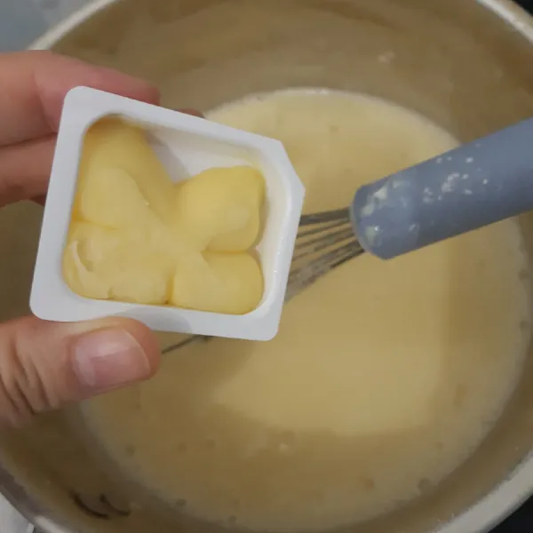Tambahkan vanilla ekstrak dan mentega, aduk rata kembali. Biarkan uap panasnya hilang