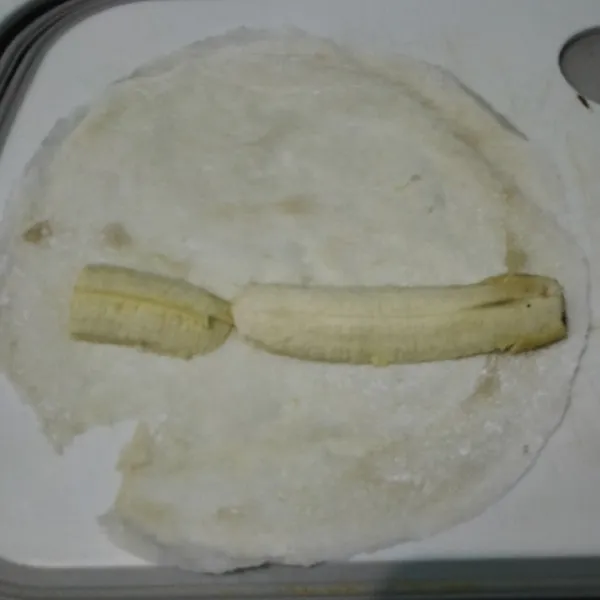 Siapkan kulit lumpia, ambil pisang yang sudah dipotong dan letakan di atasnya.