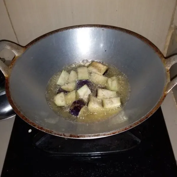 Panaskan minyak goreng. Goreng terong ungu hingga layu. Angkat dan tiriskan