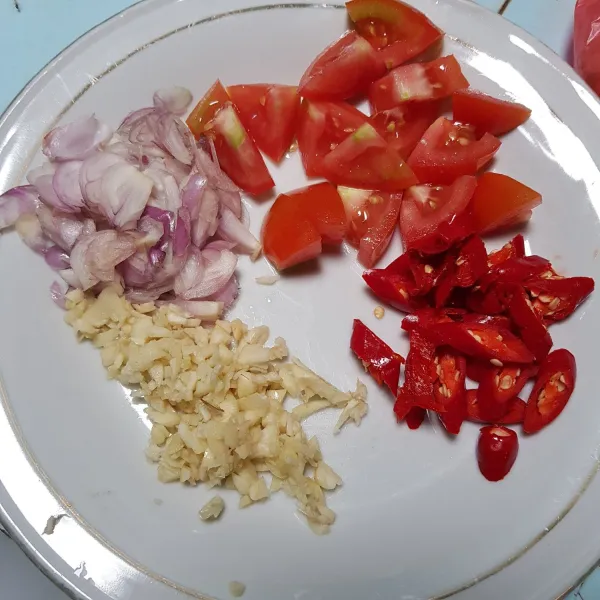 Siapkan irisan bawang putih, bawang merah, cabai merah, dan tomat.