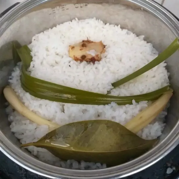 Masukkan beras yang telah dicuci bersih bersama serai, daun salam, daun pandan, dan air. Masak seperti biasa memasak nasi di rice cooker.