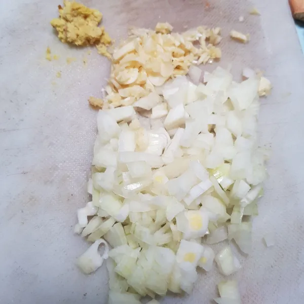 Siapkan dan iris bawang bombay dan bawang putih.