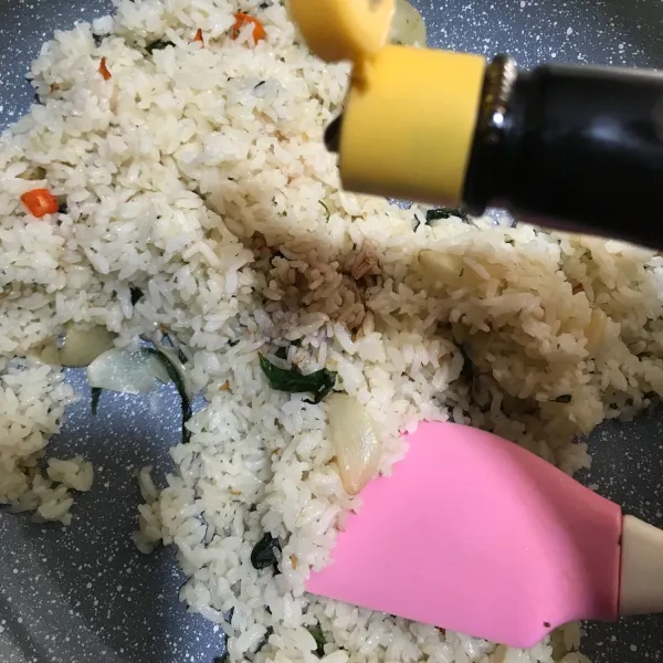 Setelah nasi sudah bercampur, lalu masukkan kecap asin dan minyak wijen