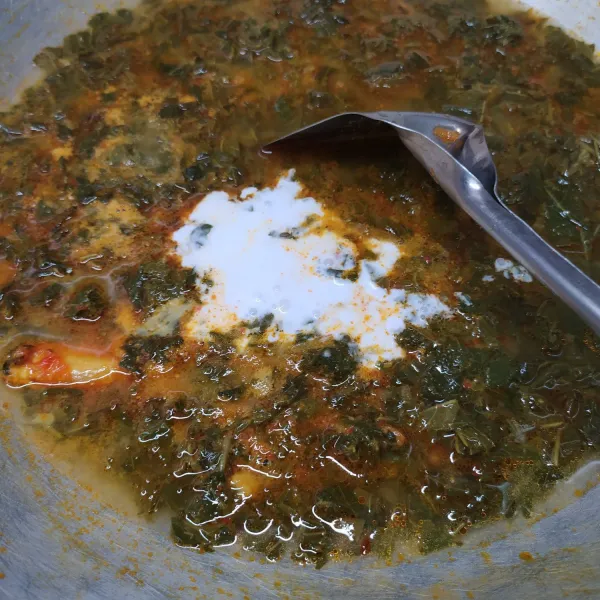 Masukkan rebusan daun singkong, air, santan instan, garam, gula, dan kaldu bubuk. Aduk rata sambil koreksi rasa sesuai selera. Masak sampai mendidih. Siap disajikan.