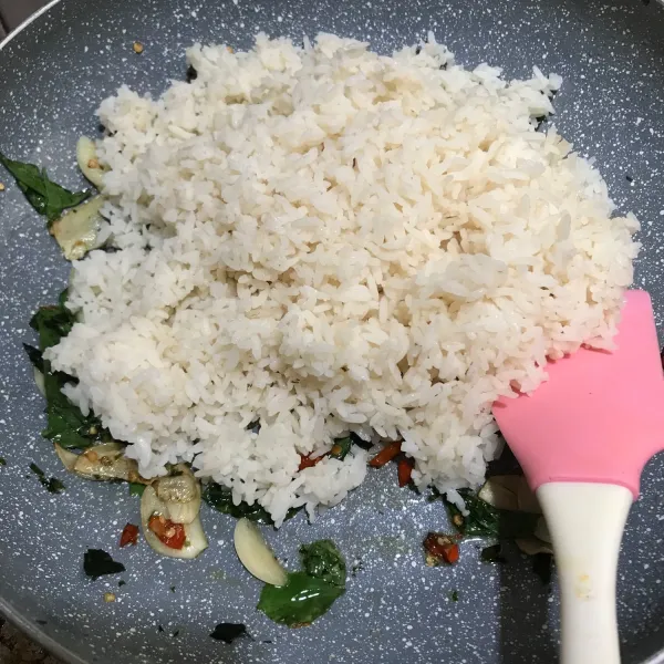 Masukkan nasi ke dalam penggorengan lalu balur dengan bumbu tumis