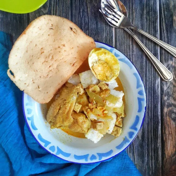 Sajikan sayur lodeh dengan potongan lontong, opor ayam, separo telur, sambal dan kerupuk udang.