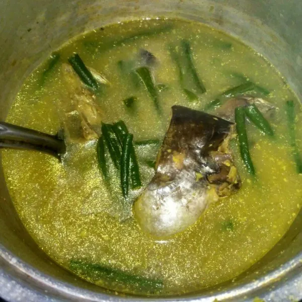 Masak hingga ikan dan kacang panjang matang, cicipi rasanya dan sajikan.