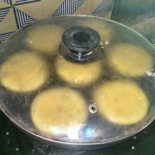 Bila bagian atas kue sudah nampak berlubang, tutup cetakan dan masak hingga matang.