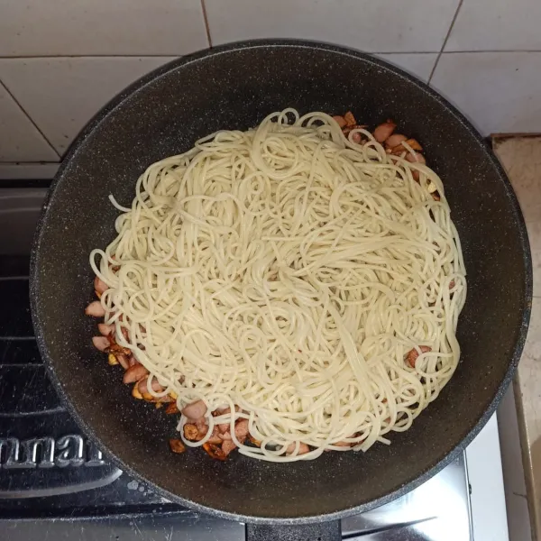 Masukan spaghetti, tambahkan bumbu, dan aduk hingga rata