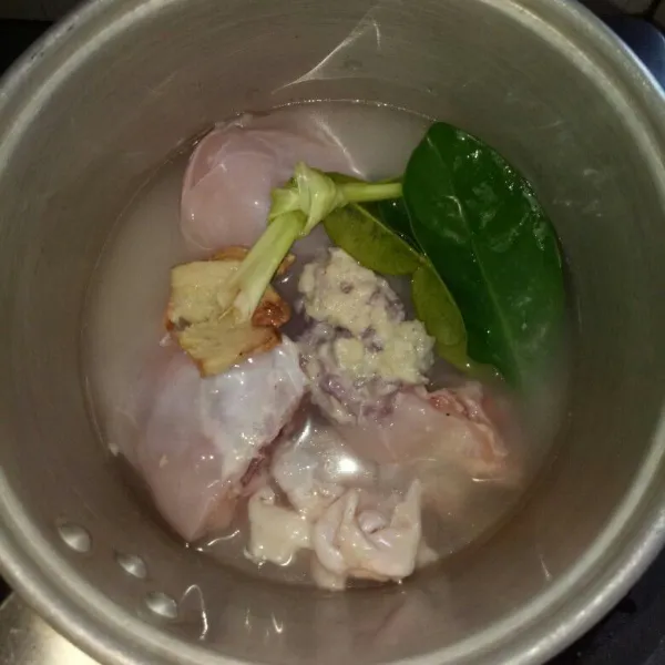 Siapkan panci, masukan ayam, bumbu halus, gula, daun salam, daun jeruk, serai, laos, jahe dan air kelapa. Aduk rata, masak dengan api kecil sampai ayam empuk. Sisakan air kaldu untuk sambal dan merebus daun singkong.