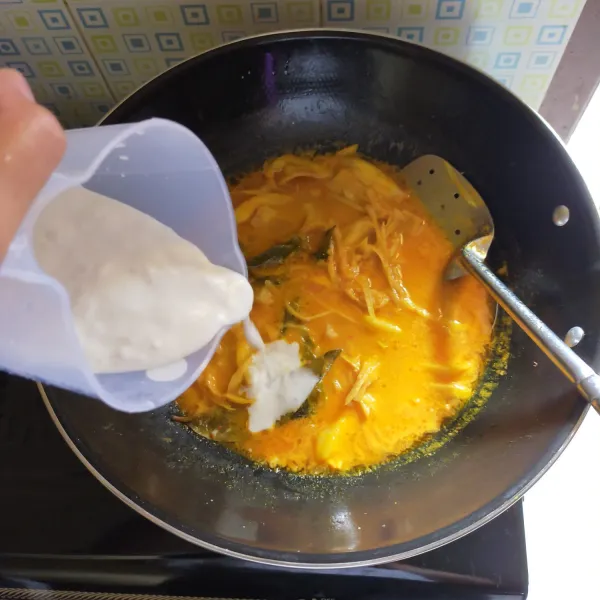 Setelah nangka empuk, masukkan santan, garam, ketumbar bubuk, dan kaldu bubuk.