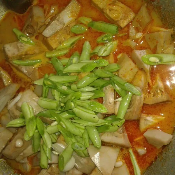 Masukkan nangka yang sudah direbus dan irisan buncis, aduk rata. Masak dengana api kecil sampai airnya sedikit menyusut.