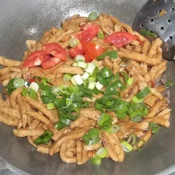 Tambahkan irisan daun bawang dan tomat. Aduk rata dan masak hingga kuah menyusut. Matikan api dan siap disajikan.