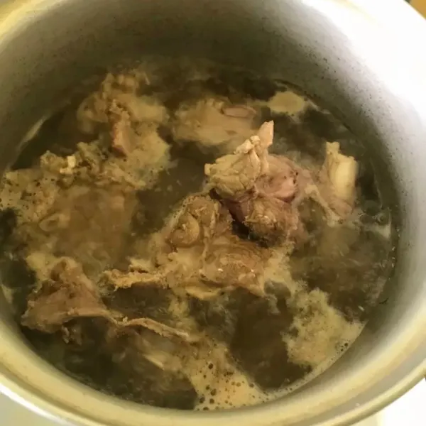 Panaskan air setengah matang lalu masukkan daging. Rebus daging hingga setengah matang.