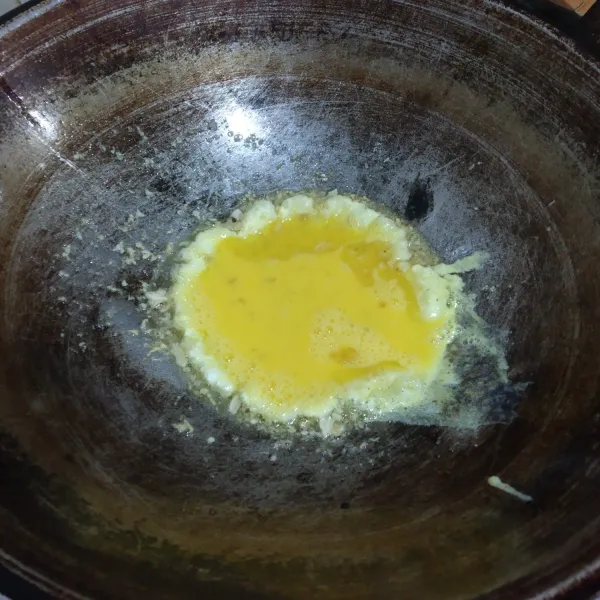 Masukkan kocokan telur, diamkan sampai telur setengah matang, lalu orak arik dengan bumbu.