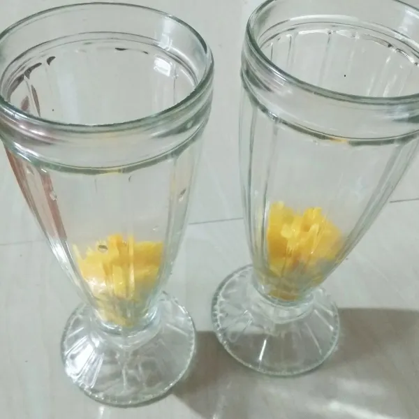 Dalam gelas saji. Masukkan potongan mangga.