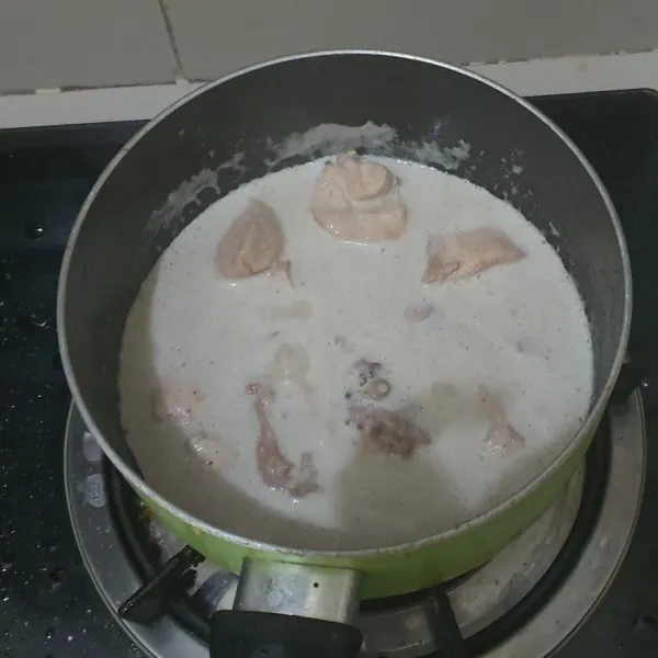 Rebus ayam yang dipotong kecil bersama bumbu halus, air kelapa dan garam. Rebus sampai air susut.