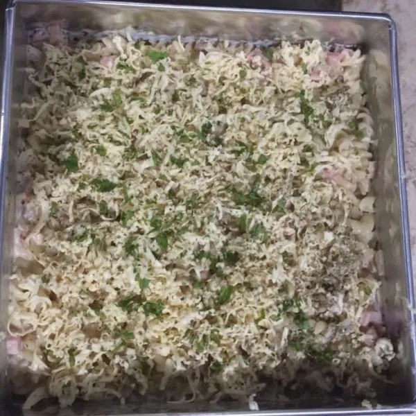 Tambahkan parutan keju cheddar, parsley dan oregano kemudian panggang di dalam oven selama 15 menit dan siap disajikan.
