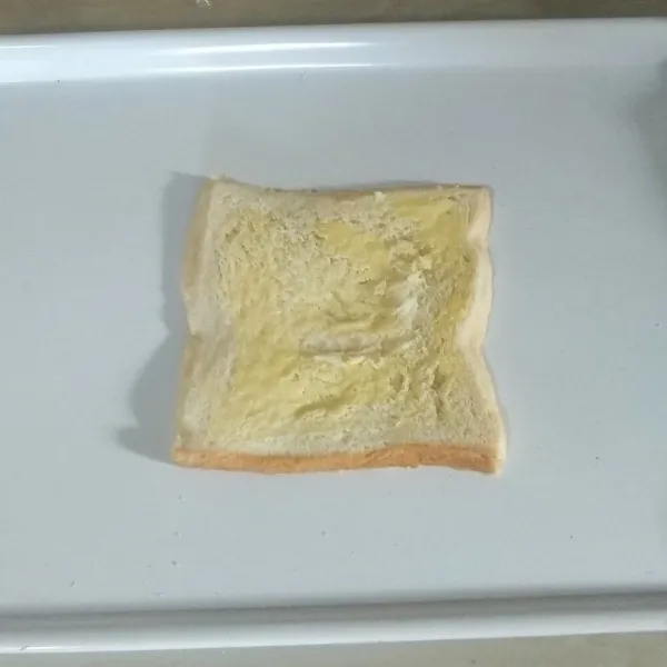 Giling roti pakai rolling pin agar gepeng. Oles sisi atasnya dengan mentega. Lalu digulung perlahan (yang di oles mentega posisinya bagian dalamnya).