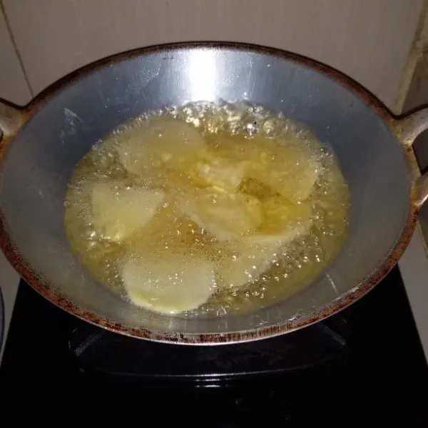 Panaskan minyak goreng. Masukan irisan kentang. Goreng hingga setengah kering. Angkat dan tiriskan.