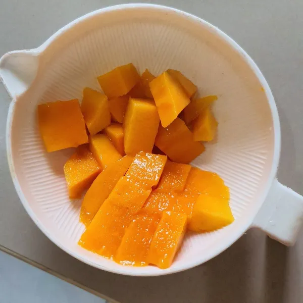 Potong mangga dan sisihkan sedikit untuk topping.