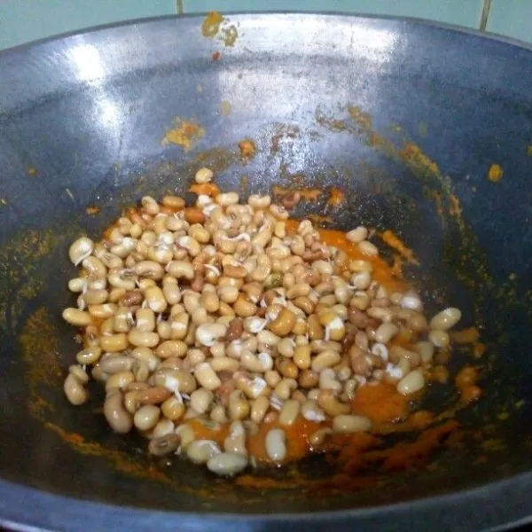 Tumis bumbu halus & daun salam sampai harum sedap, masukkan kacang tolo, aduk rata, lalu tuangi air.
